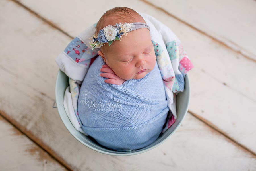 newborn wrapped baby girl in blue, vintage quilt