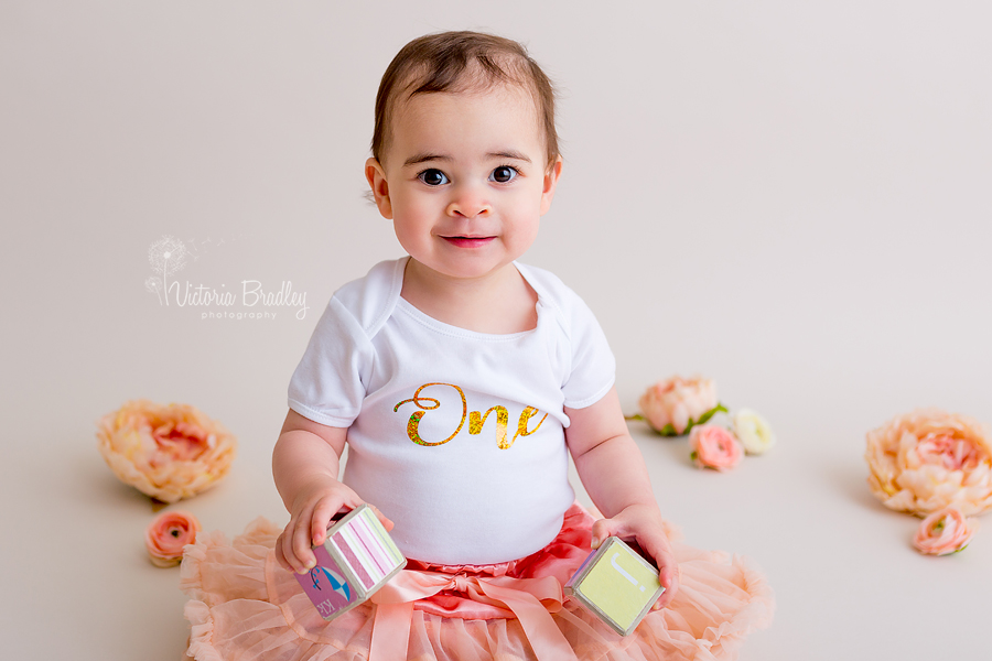 baby girl with peach tutu and peach flowers with a white and gold one top