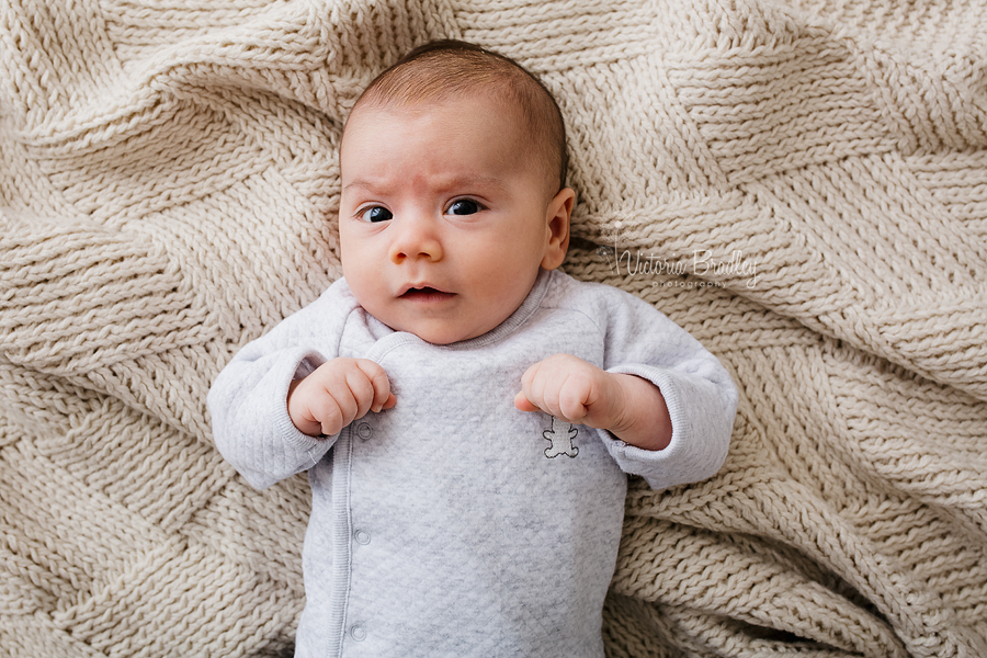 newborn baby boy on cream throw