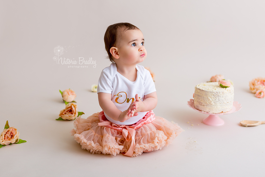 1 year old baby girl birthday cake smash with peach tutu and flowers