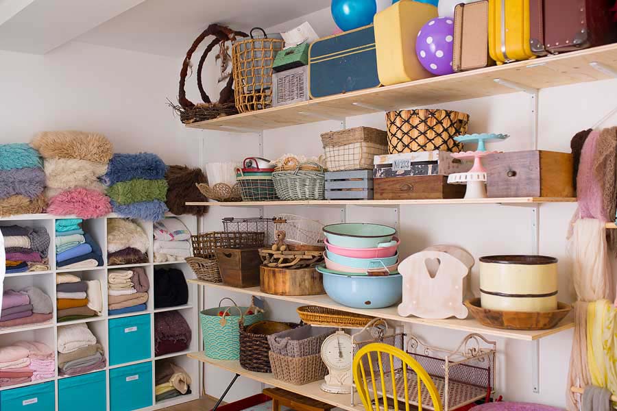 a large collection of different coloured flokati rugs with coloured throws and photo studio props
