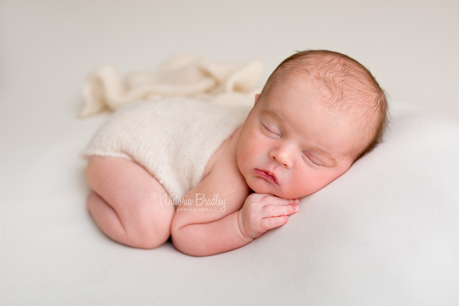 baby bot on tummy on cream blanket