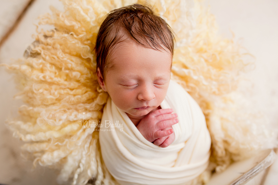 baby newborn with yellow wrap and yellow curly layer