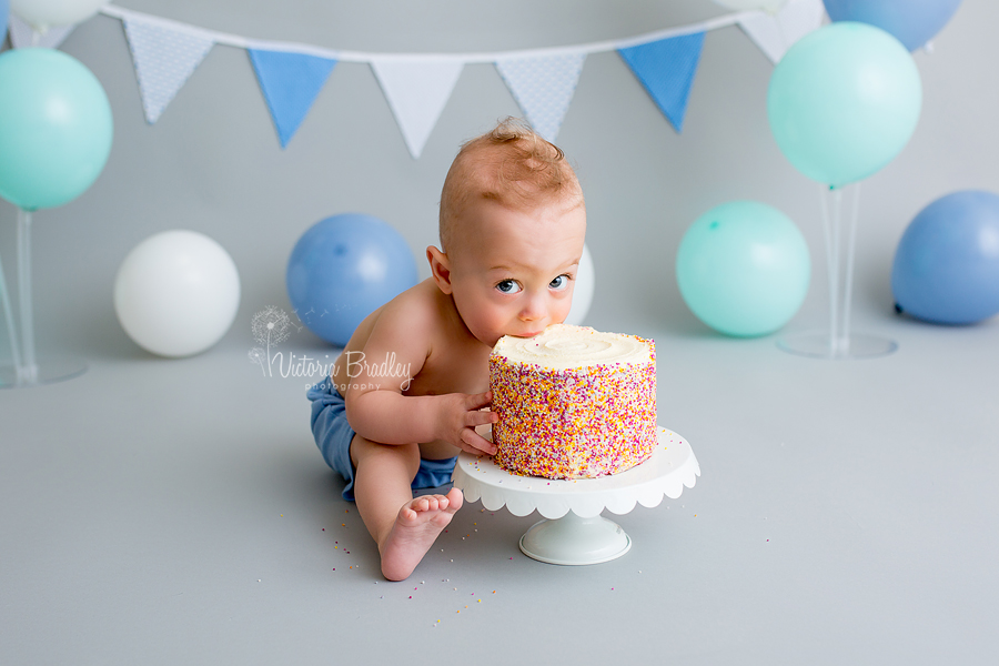 baby boy eating marks and spencer rainbow cake, smash cake