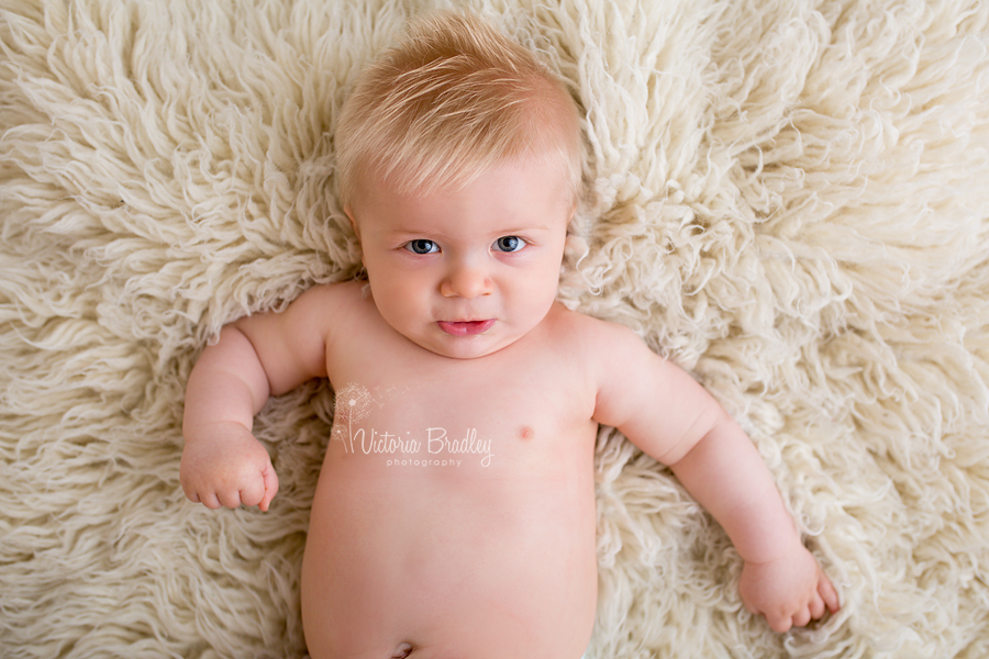 baby boy lay on cream flokati rug