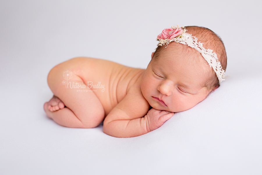 newborn baby girl on white backdrop