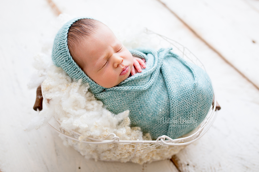 wrapped newborn with light jade knitted wrap