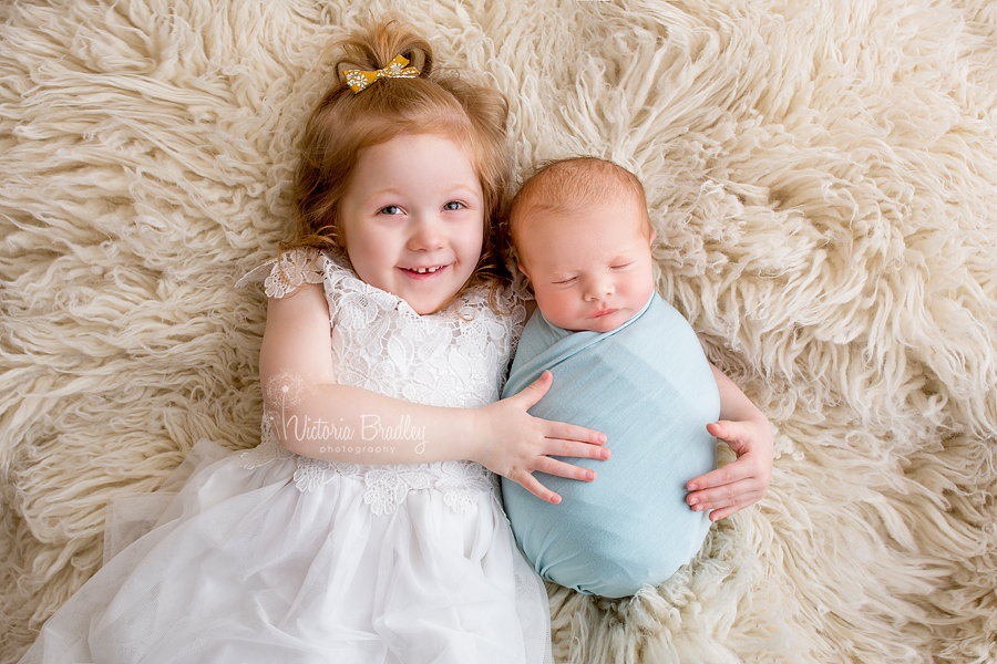 sibling and newborn shots on cram flokati