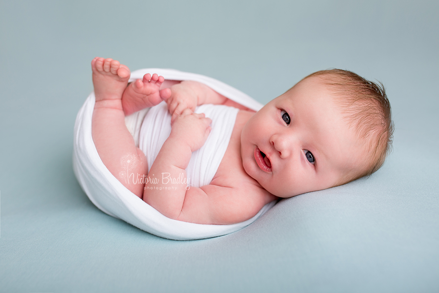 baby boy newborn photography session with white wrap on duck egg backdrop