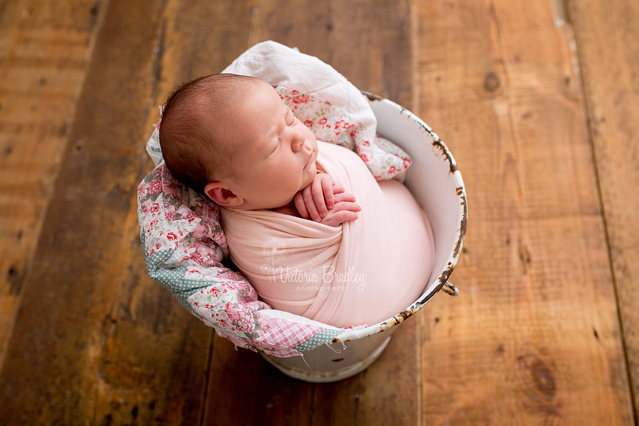 baby in a white metal bucket