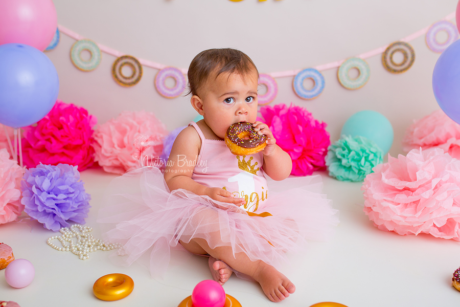 doughnut cake smash baby girl eating a chocolate doughnut