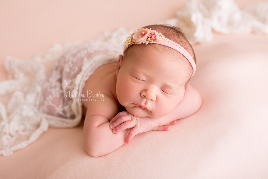 peach backdrop with newborn baby, with peach tie-back