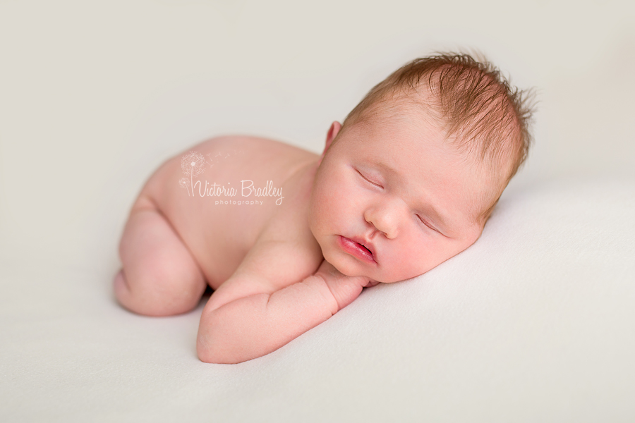 newborn baby on pale lemon backdrop during newborn photography session in Mansfield