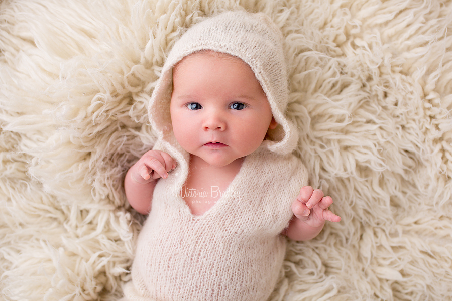 baby boy with cram knitted hoodie on cram flokati