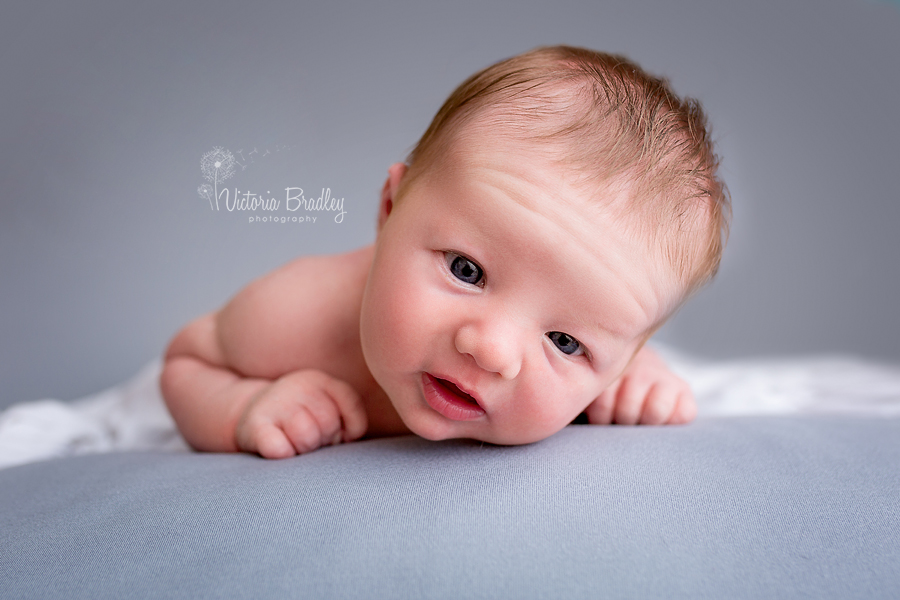 baby boy newborn photography session on a grey backdrop