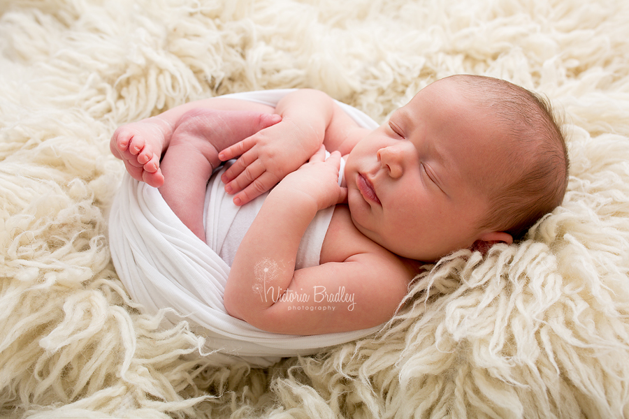 newborn baby girl on cream flokati