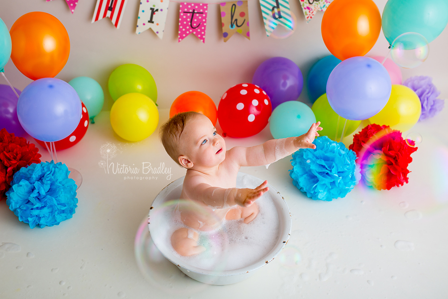 rainbow cake smash vintage white bath tub baby boy catching bubbles