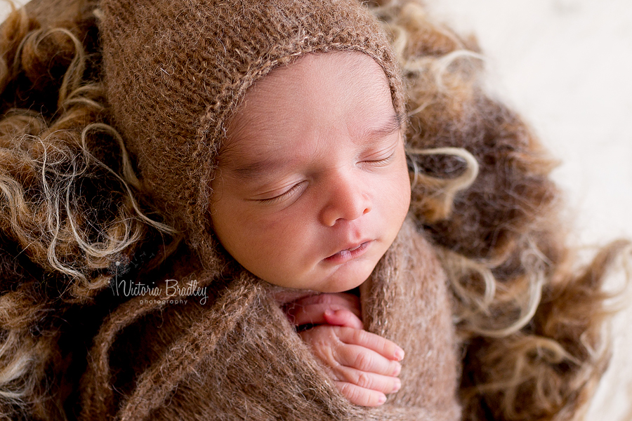 wrapped newborn in brown wrap and bonnet