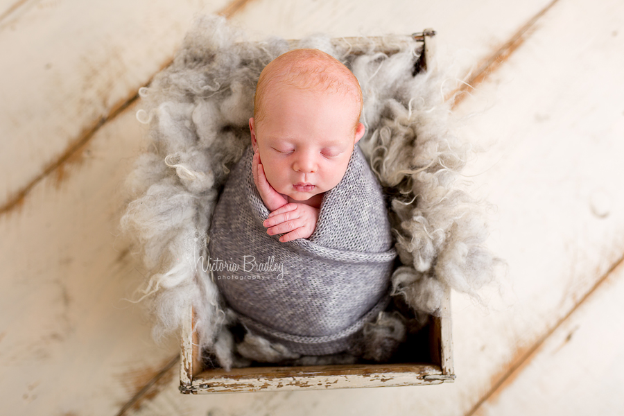 newborn baby boy photography session wrapped baby in grey