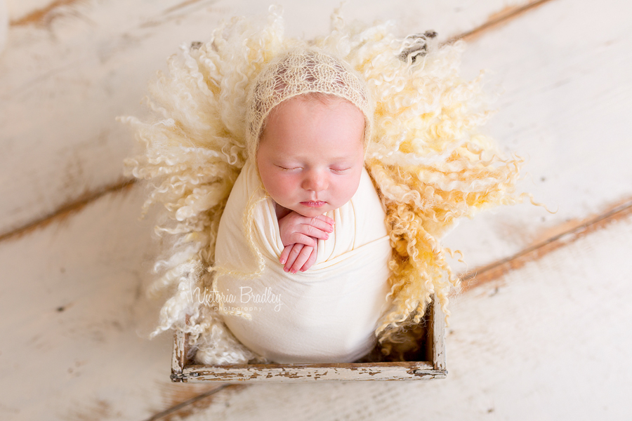 wrapped newborn baby girl in yellow wrap