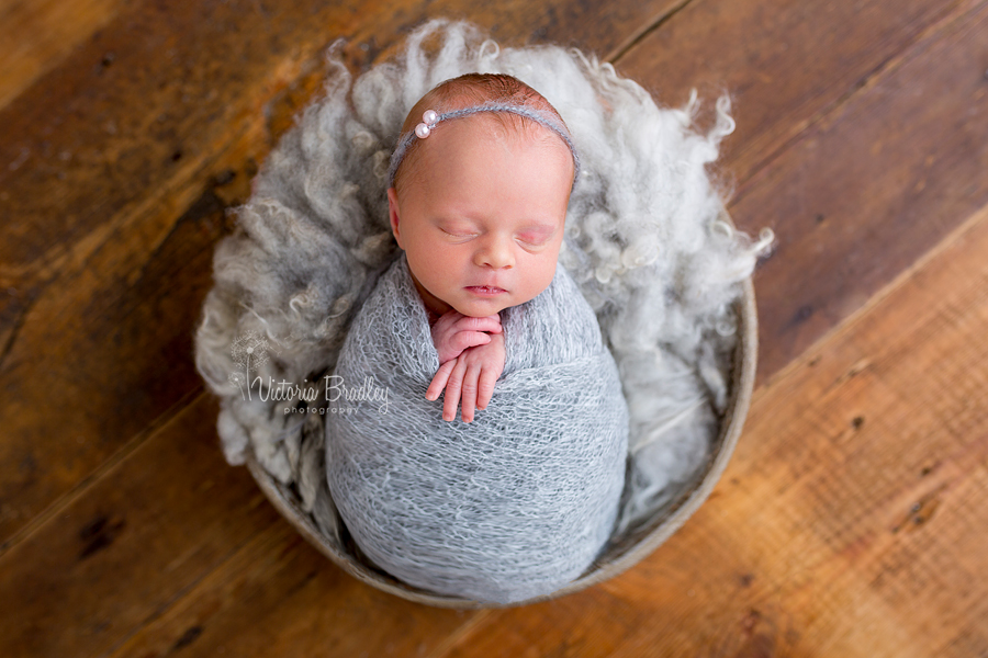 newborn baby in grey wrap