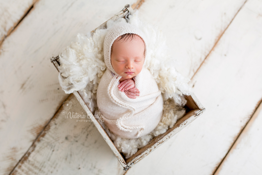 wrapped newborn baby boy photography sessions cream knitted wrap in a cream crate