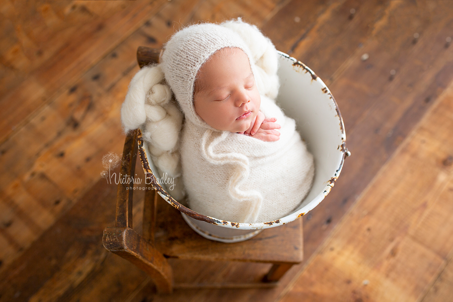 newborn photography session wrapped baby in bucket