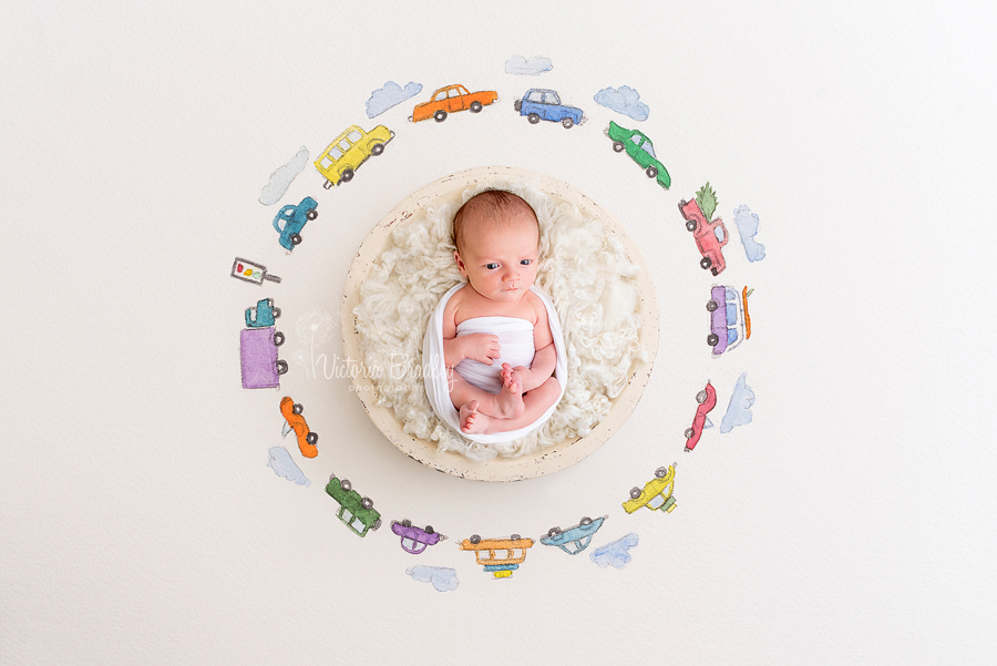 newborn photography session, baby boy in white fur with painted car background