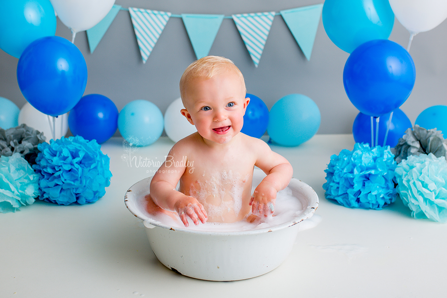 bath tub splash session, white tub on grey backdrop with blue ballons