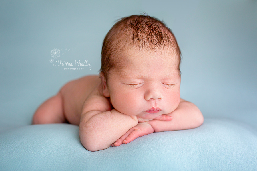 newborn baby chin on hands pose on duck egg backdrop photography session