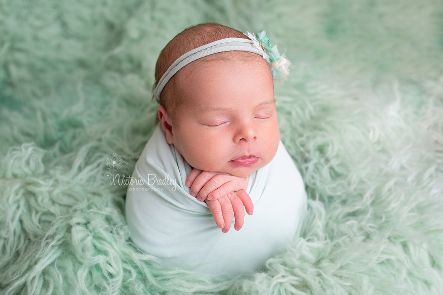 newborn baby photography girl in mint wrap on mint flokati