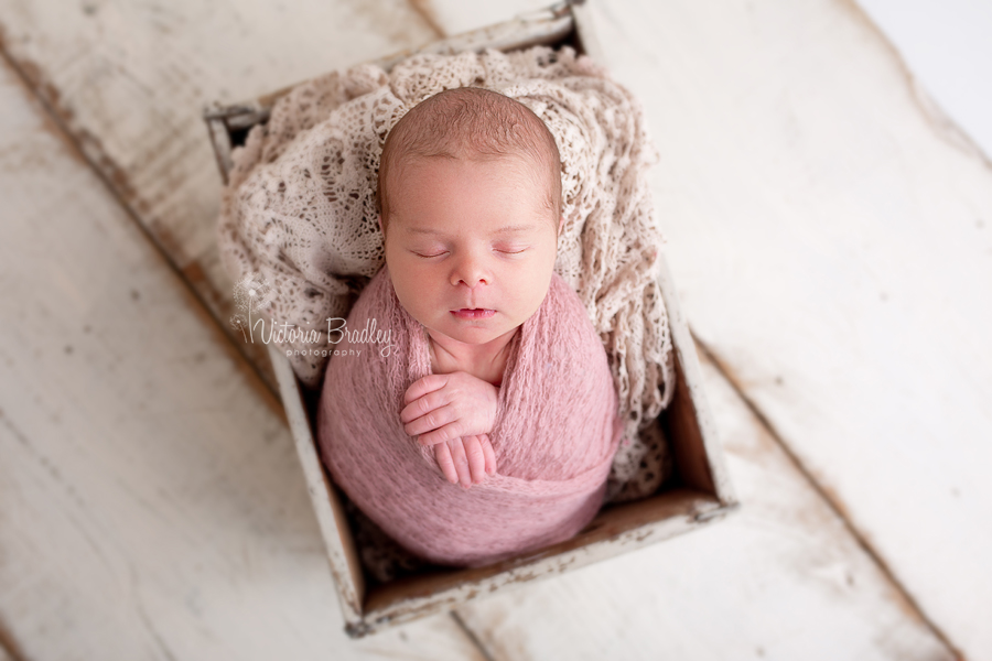 baby photography, wrapped baby in dusky pink wrap in wooden crate