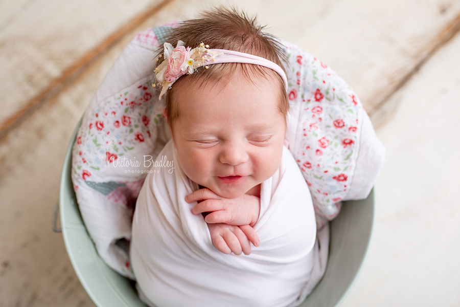 smiling baby newborn in bucket