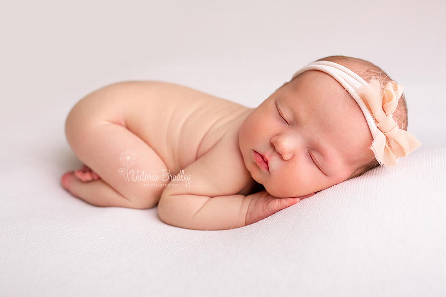 baby girl on cram blanket with bow head band