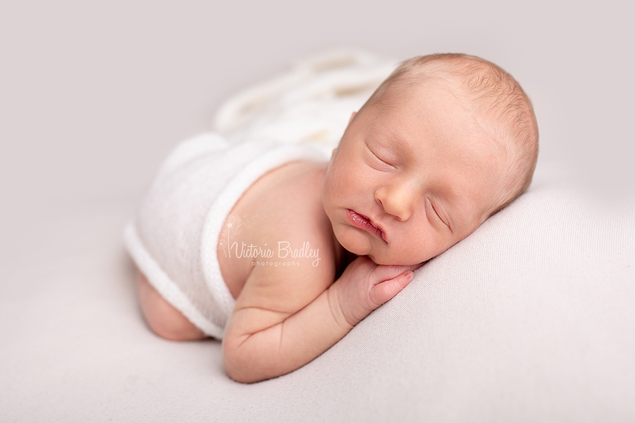 newborn baby boy alseep on tummy