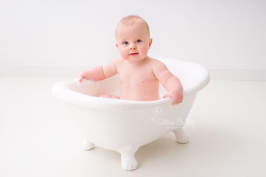 baby boy sitter in white bath tub