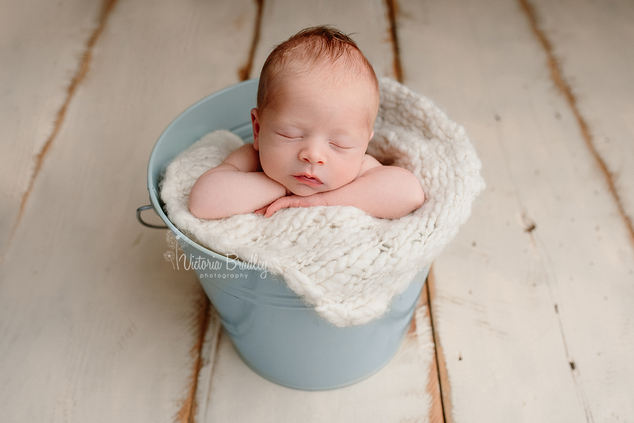 newborn baby photography, in blue bucket, chin on hands pose