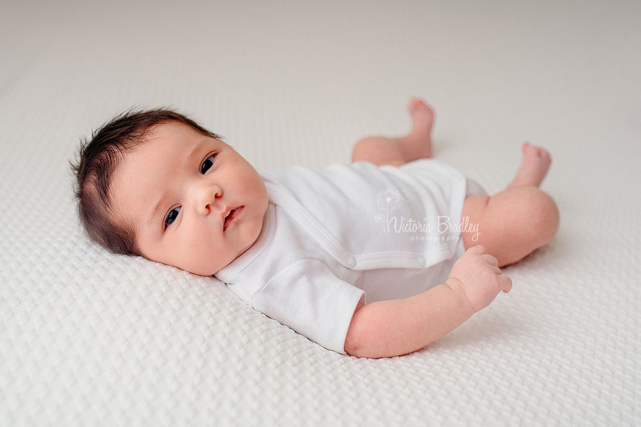 baby girl on white backdrop newborn photography