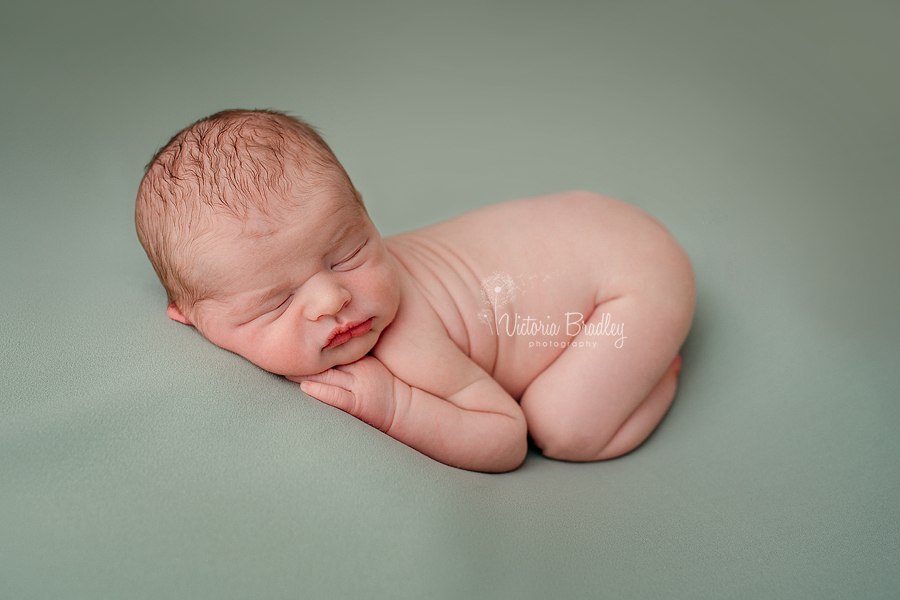 newborn baby boy photography session on sage green blanket