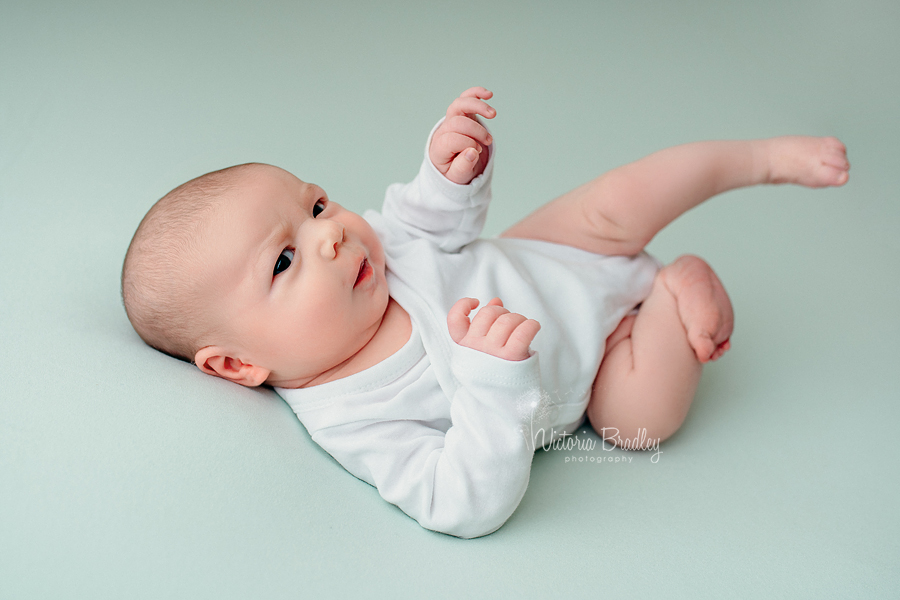 newborn baby on mint backdrop