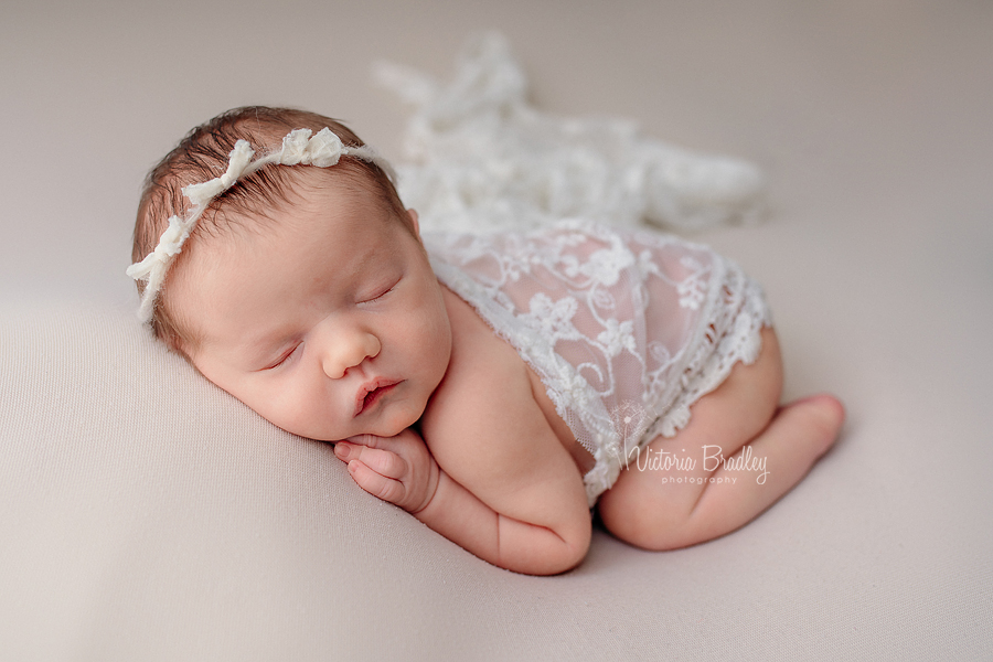 tummy pose of newborn on cream backdrop newborn photo session