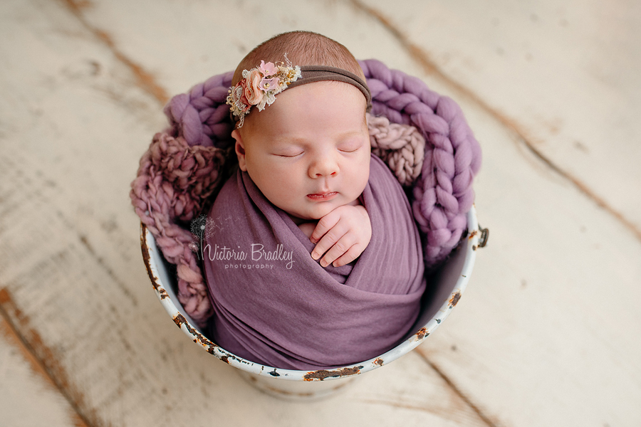wrapped baby photography in bucket with purples