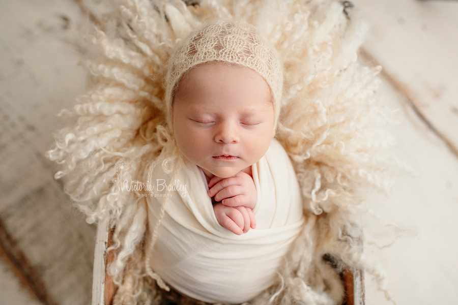 swaddled baby in pale yellows