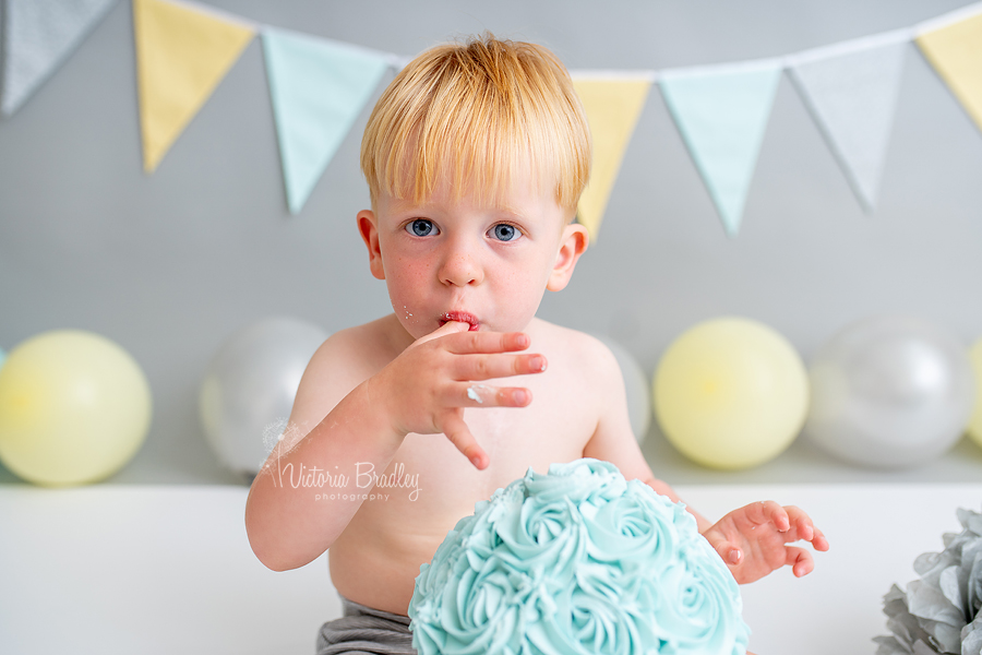 2 year old boy cake smash eating cake