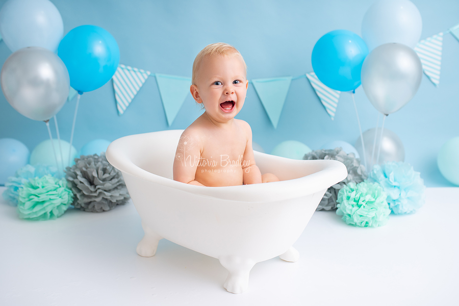 Baby boy in white bath tub for cake smash