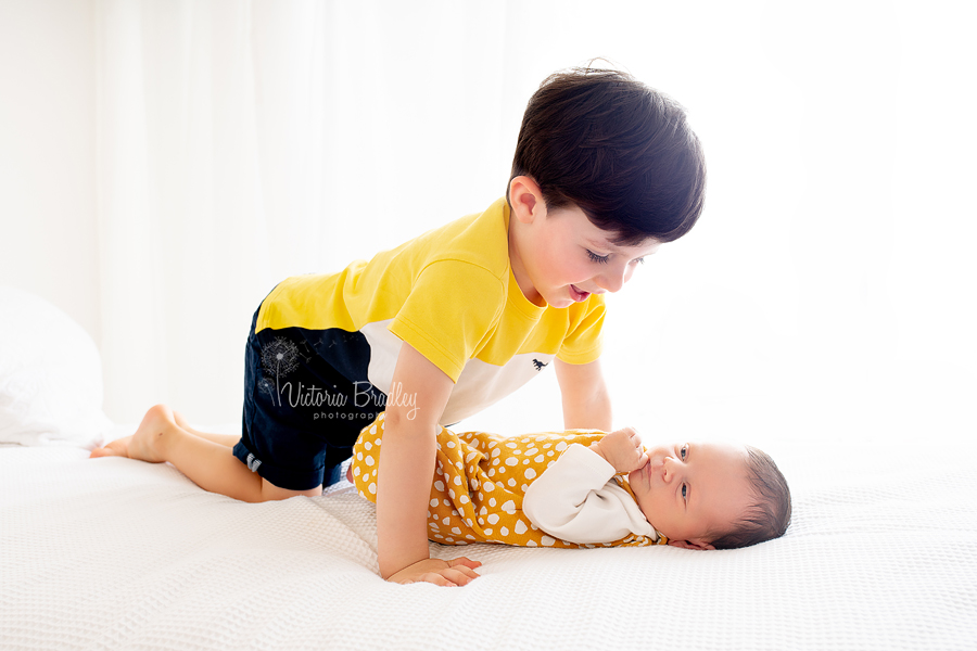 sibling and newborn photography on white. 