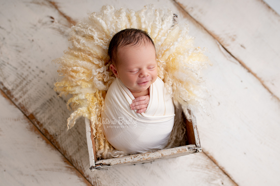 wrapped smiling newborn pastels yellows