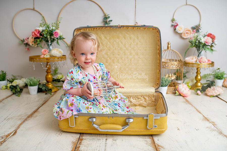 baby girl in yellow suit case