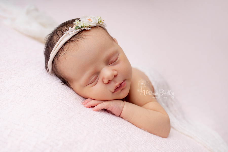 sleepy newborn on pink blanket