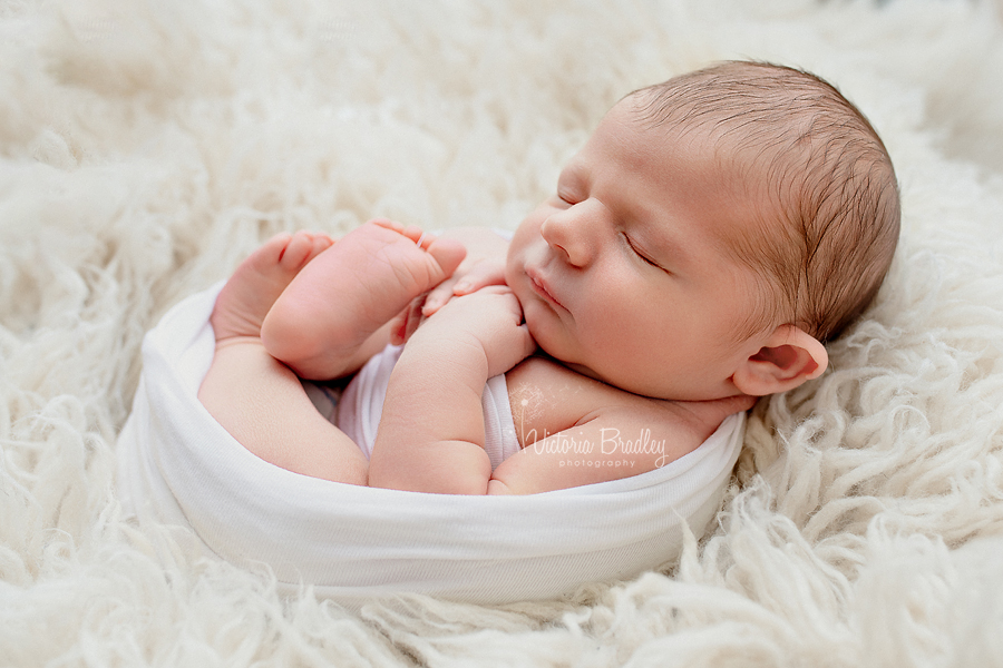 egg wrap newborn photography with white wrap on cram flokati 